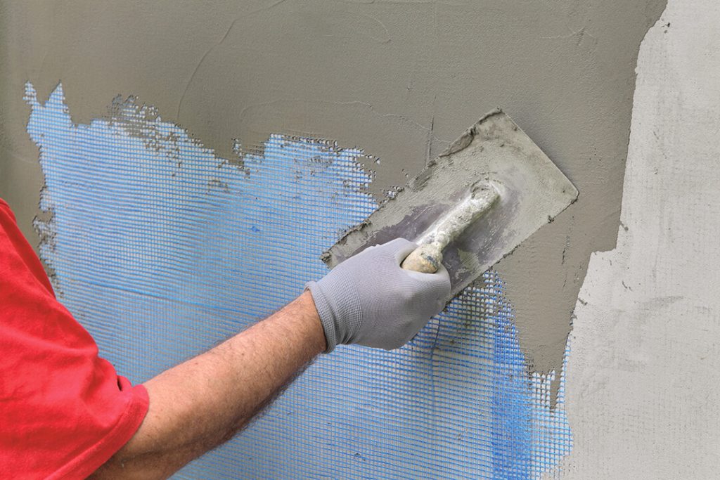 Wall insulation, spreading mortar over mesh